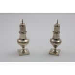 A PAIR OF GEORGE III PEPPER CASTERS on square pedestal bases with reeded borders and high-domed