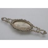 A WILLIAM IV SCOTTISH LEMON STRAINER (for a punch bowl), with twin-cast openwork handles with
