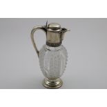 A LATE VICTORIAN MOUNTED CUT-GLASS CLARET JUG with an oviform body and a circular pedestal foot,