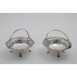 A PAIR OF LATE VICTORIAN SWING-HANDLED BONBON DISHES in the style of a George II cake basket, with