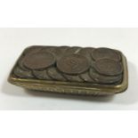 A NOVELTY COIN TOPPED MATCHBOX. A brass matchbox with sliding lid mounted with sixteen small