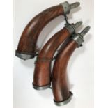 THREE REPRODUCTION POWDER HORNS AND A CLEANING BRUSH. Three horns with wooden bodies, cast mounts
