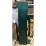 A GREEN METAL GUN CABINET WITH 2 KEYS. A green metal gun cabinet, 126cm tall, 25cm wide and 12.5cm