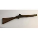 A FLINTLOCK BLUNDERBUSS. A flintlock blunderbuss with flared brass barrel, top mounted sprung