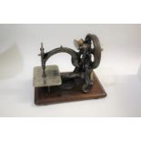 WILLCOX & GIBBS SEWING MACHINE a cast iron sewing machine mounted on a wooden plinth, marked Willcox