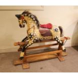 ANTIQUE ROCKING HORSE a painted wooden rocking horse, mounted on a wooden trestle base. 118cms high,