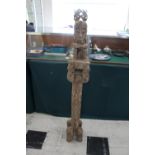 TIMOR TRIBAL FIGURE with a figure seated on top of a carved column, the column supported on 4