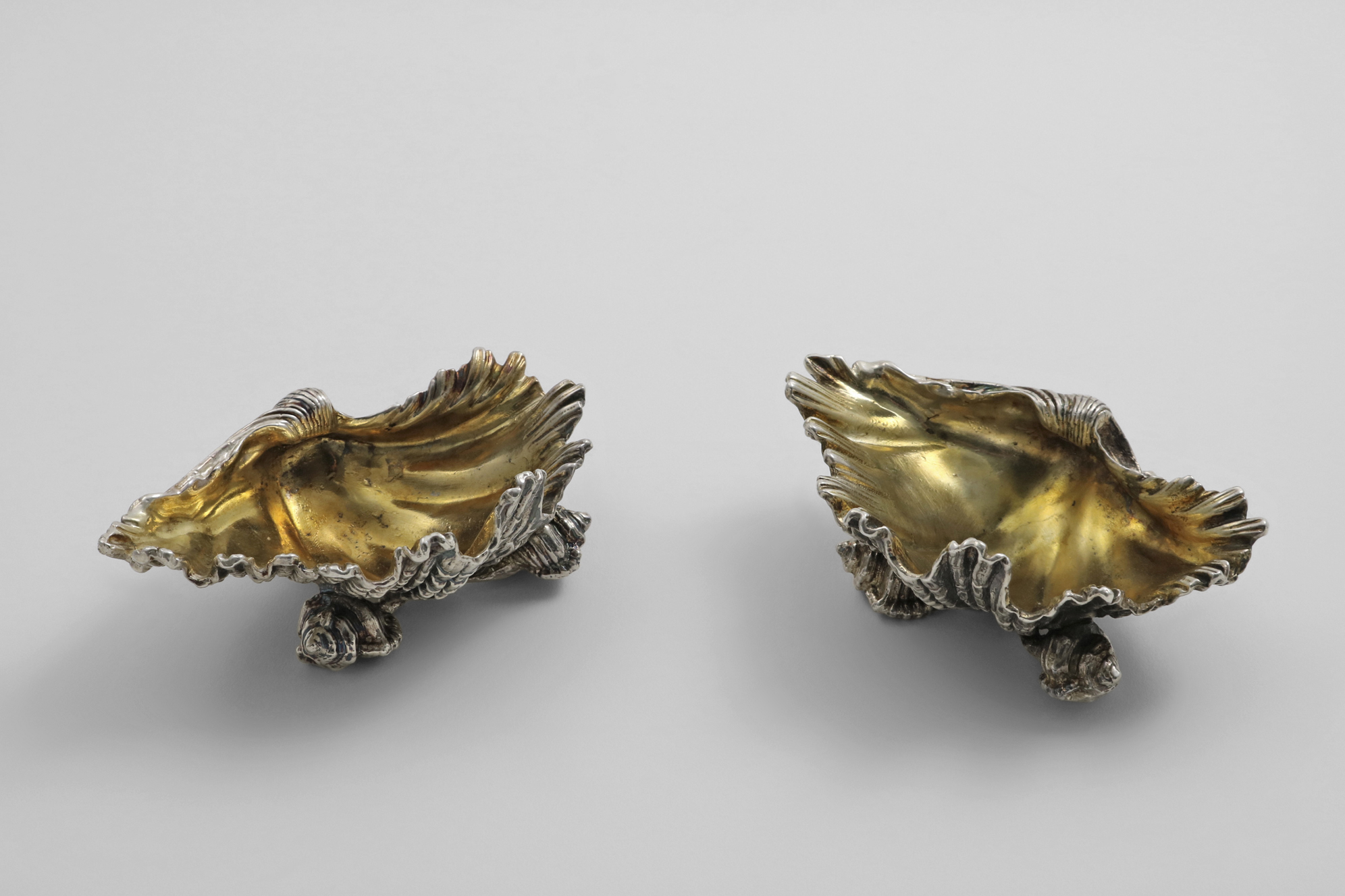 A PAIR OF VICTORIAN ELECTROPLATED CAST, NATURALISTIC SALTS in the form of shells with gilt interiors