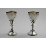 A MATCHED PAIR OF VICTORIAN GOTHIC REVIVAL GOBLETS with engraved decoration and gilt interiors, by