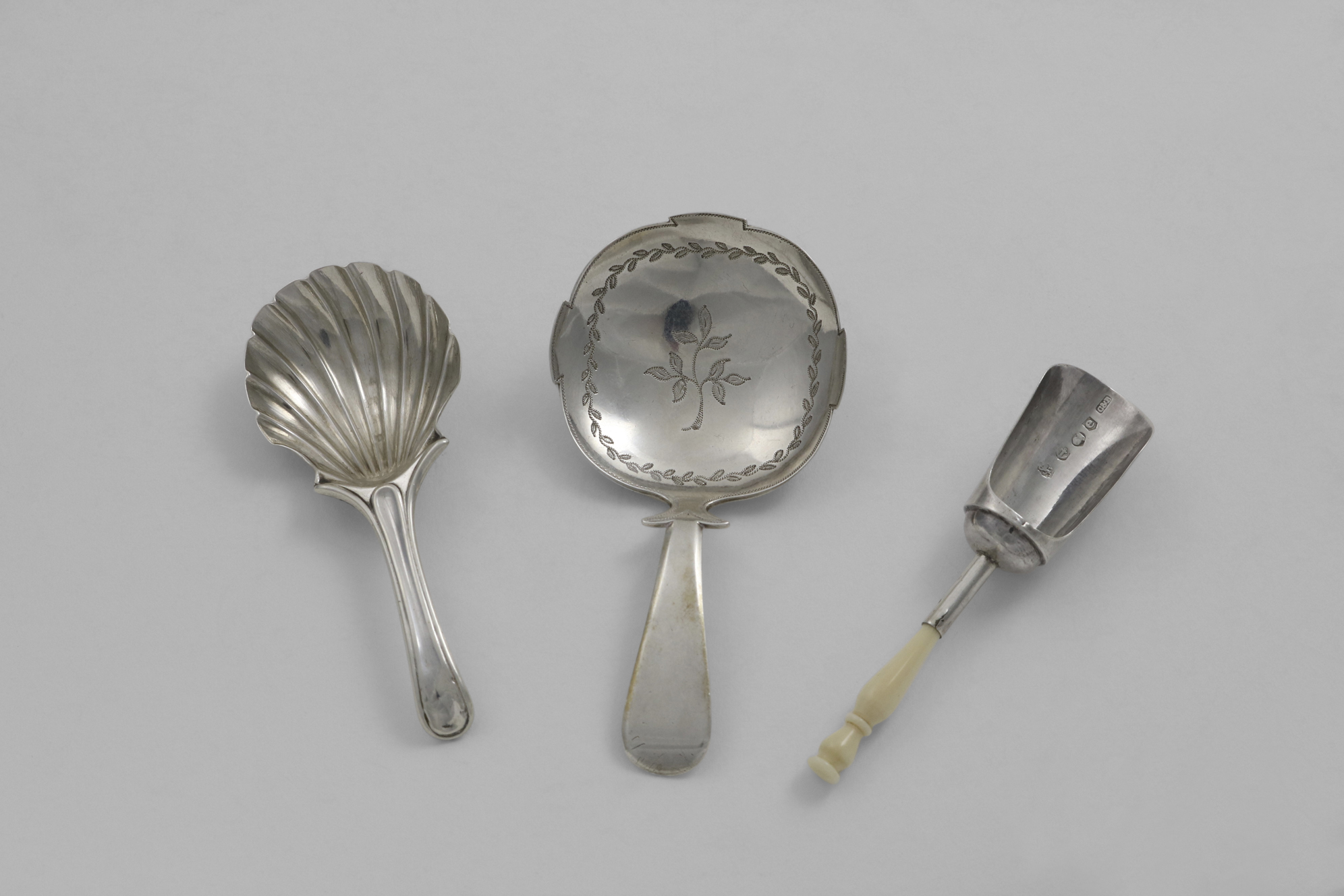 A GEORGE III CADDY SPOON with shoulders, a shaped circular bowl and engraving, by Edward