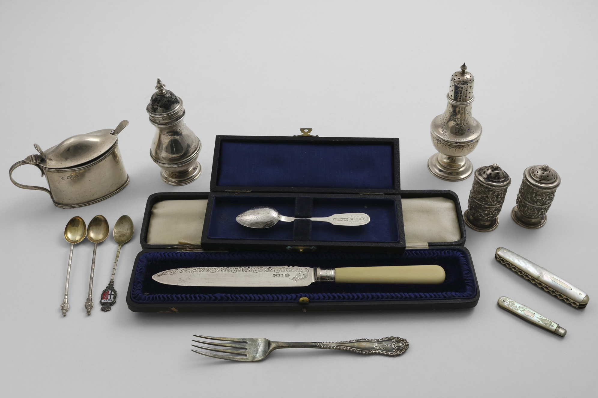A MIXED LOT:- An ivory-handled cake knife in a fitted case, a Russian engraved tea spoon (in a box),