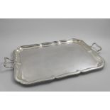 A LARGE, ELECTROPLATED, TWO-HANDLED TRAY of shaped rectangular outline with a moulded border, by