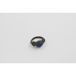 A RARE ROMANO-BRITISH BRONZE RING with a shouldered shank, set with an oval blue paste seal with