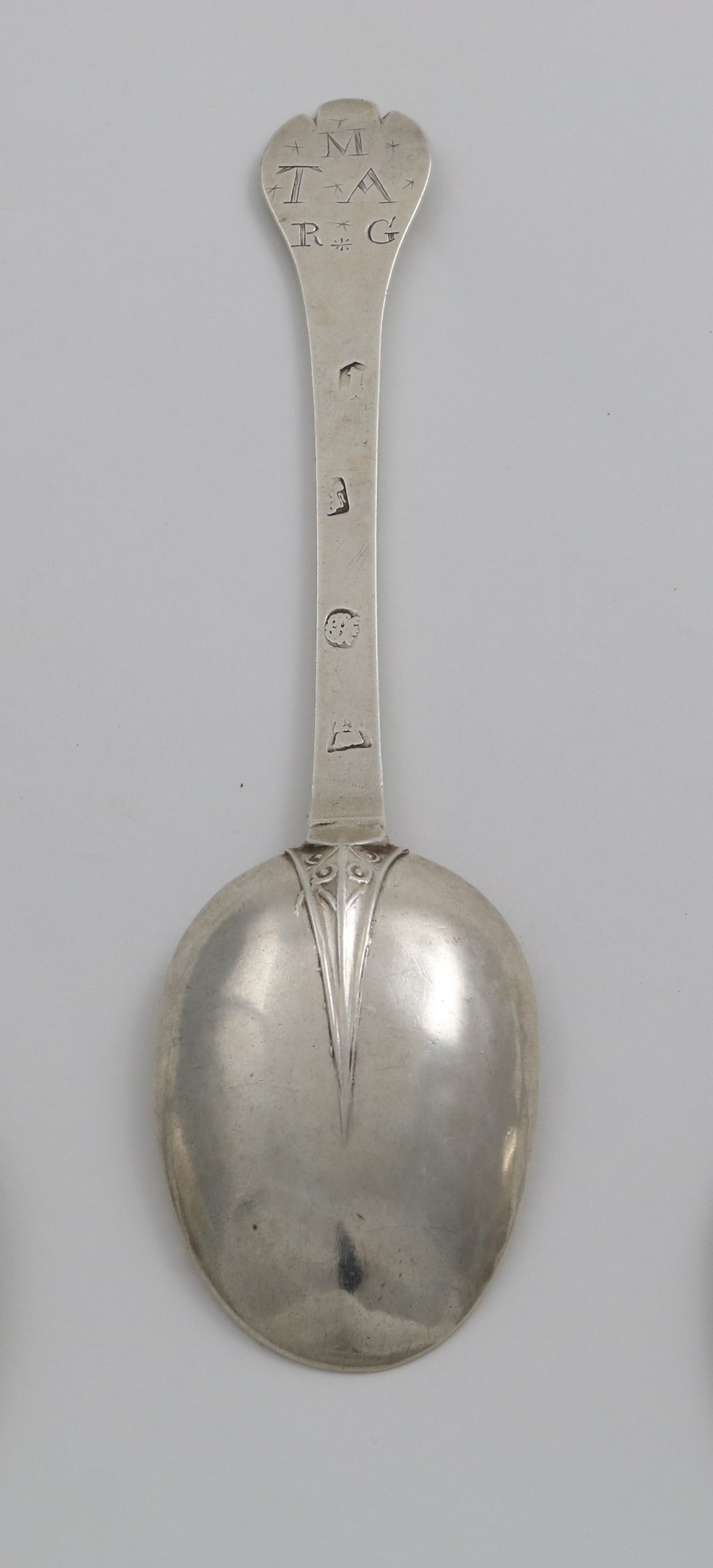 A JAMES II TREFID SPOON with a ribbed and scroll decorated rattail, the back of the terminal