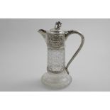 A LATE VICTORIAN MOUNTED CUT-GLASS CLARET JUG on a spreading, star-cut base, with an embossed