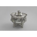 AN EARLY VICTORIAN TEA OR SUGAR CADDY of bombe form with embossed floral decoration, a border of