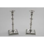 A PAIR OF LATE 20TH CENTURY ELECTROPLATED CAST CANDLESTICKS on square bases with gadrooned