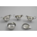 A MIXED LOT:- A pair of small Edwardian sauce boats on three legs with shaped cut rims, by