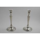 A PAIR OF GEORGE III CANDLESTICKS on reeded circular bases with fluted tapering columns and fluted