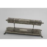 AN EARLY 20TH CENTURY SCROLL HOLDER on a rectangular stand with chased decoration & paw feet, the