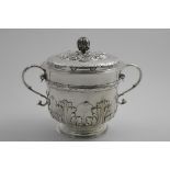 A LATE VICTORIAN TWO-HANDLED CUP AND COVER in the style of a Charles II porringer with embossed