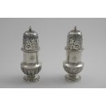 A PAIR OF EARLY 20TH CENTURY FRENCH SUGAR CASTERS in the Regence style, with high-domed bayonet-