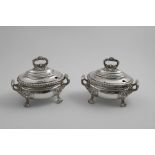 A PAIR OF OLD SHEFFIELD PLATED OVAL SAUCE TUREENS & COVERS with decorative feet and handles and