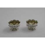 A PAIR OF WILLIAM IV LOBED CIRCULAR SALTS on lobed pedestal bases, crested, gilt interiors, by