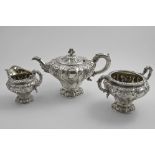 A WILLIAM IV SCOTTISH THREE-PIECE TEA SET with repousse-work decoration, circular pedestal bases and