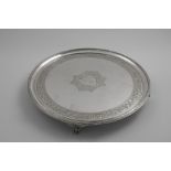 A GEORGE III CIRCULAR SALVER with a reeded rim and bracket feet, decorated around the border with