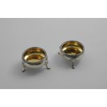 A PAIR OF GEORGE III SQUAT CIRCULAR SALTS on three legs with corded rims and gilt interiors,