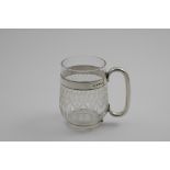 A VICTORIAN MOUNTED CLEAR GLASS MUG with a c-shaped handle, the body cut with a repeating frieze