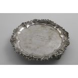 AN EARLY 19TH CENTURY SMALL SALVER with an embossed floral scroll border, cast openwork feet and