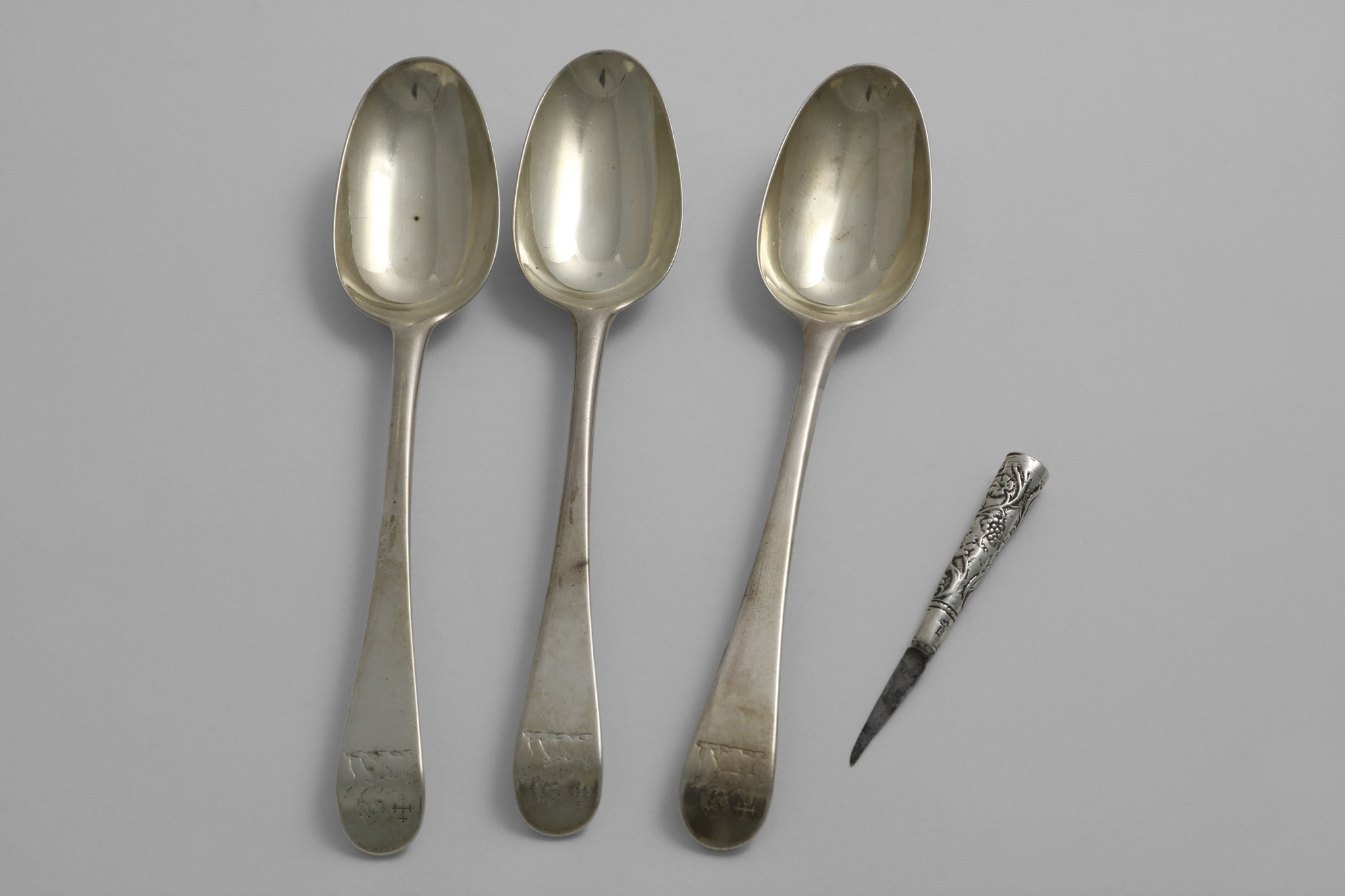 A SET OF THREE GEORGE III OLD ENGLISH PATTERN TABLE SPOONS crested, maker's mark "IL" (script),