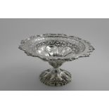 AN EARLY 20TH CENTURY PIERCED FRUIT TAZZA of shaped circular outline with a floral scroll border and