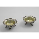 A PAIR OF VICTORIAN SALTS of shaped circular outline with wavy, reed and ribbon borders, and four