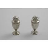 A PAIR OF EARLY 19TH CENTURY INDIAN COLONIAL PEPPERETTES of vase form with bun covers, crested, by