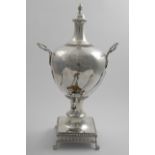 A GEORGE III TWO-HANDLED TEA URN with an oviform body, decorated with wrythen fluting, on a