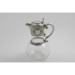 A VICTORIAN MOUNTED CLEAR GLASS CLARET JUG with a star-cut base and a scroll handle, the mount