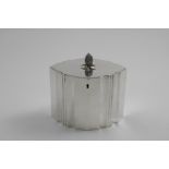 A GEORGE III TEA CADDY navette shaped with shaped, fluted sides, a flush-fitting cover and a