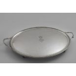 A GEORGE III TWO-HANDLED OVAL TRAY with reeded borders and reeded bracket feet, engraved in the