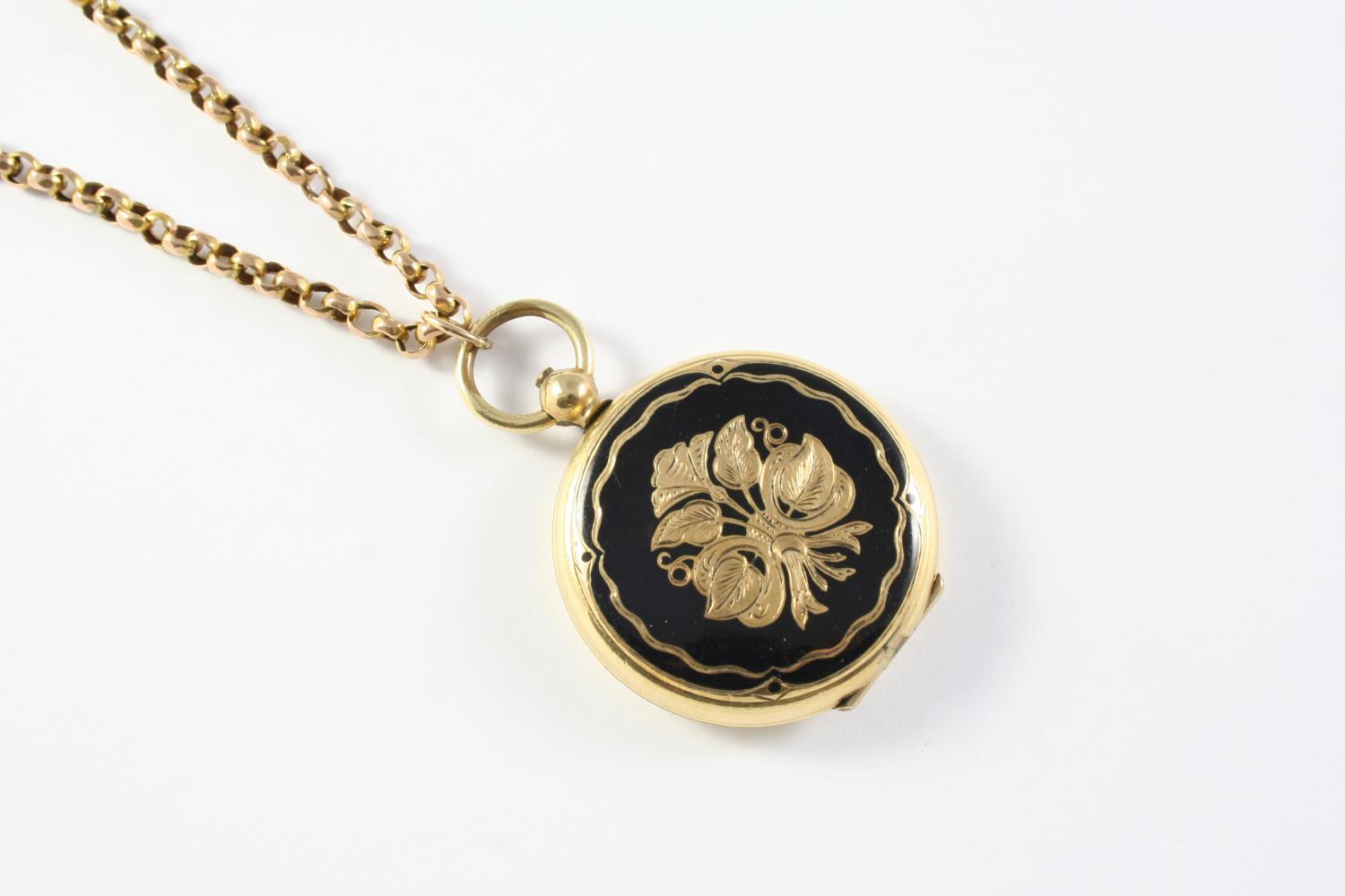 A 9CT GOLD CHAIN suspending a circular gold locket pendant, with black enamel and gold foliate