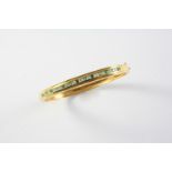 AN EMERALD, DIAMOND AND GOLD HALF HINGED BANGLE the gold bangle is mounted to one side with