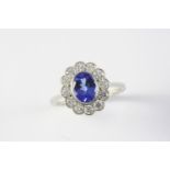 A TANZANITE AND DIAMOND CLUSTER RING the oval-shaped tanzanite is set within a surround of