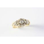A LATE VICTORIAN DIAMOND CLUSTER RING of flowerhead form, set overall with circular old cut and