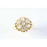 A DIAMOND CLUSTER RING the flowerhead design is set with seven old cushion-shaped diamonds, in