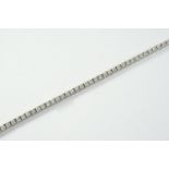 A DIAMOND LINE BRACELET formed with forty six circular-cut diamonds in 18ct white gold, 18cm long