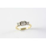 A DIAMOND THREE STONE RING the round brilliant-cut diamond is set with two princess-cut diamonds, in