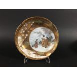 JAPANESE SATSUMA QUATREFOIL DISH by Taniguchi, painted with a circular cartouche of maidens in a