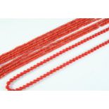 A SINGLE ROW UNIFORM CORAL BEAD NECKLACE the coral beads measure approximately 5.8mm, set to a 9ct